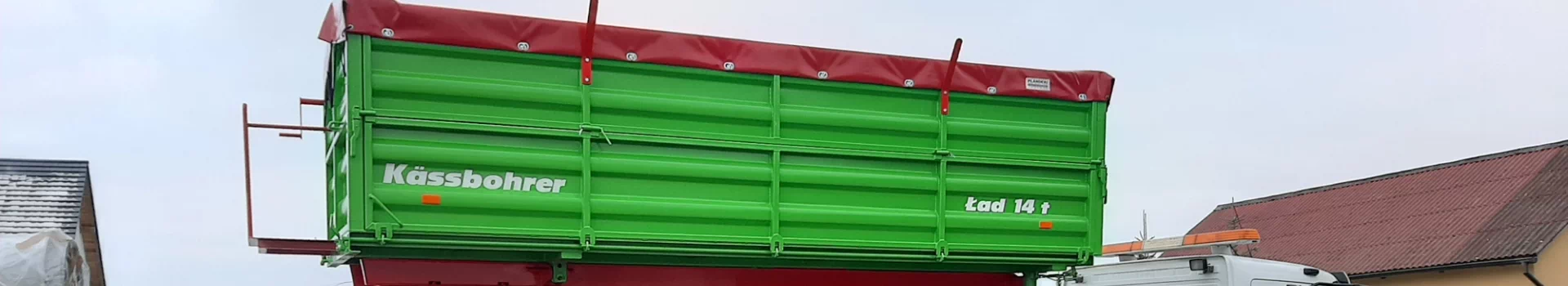 zielona przyczepa z czerwonymi elementami